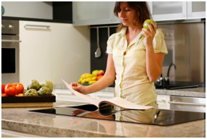 basic cooking skills woman with recipe book in kitchen