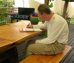 man writing in a journal